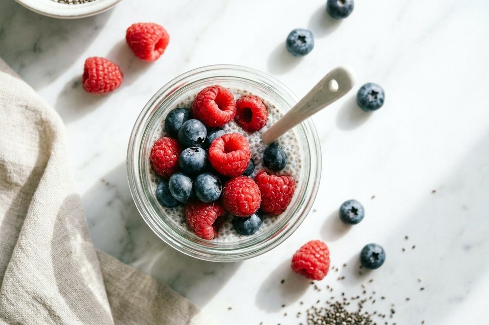 Jar of vanilla chia pudding topped with fresh raspberries and blueberries